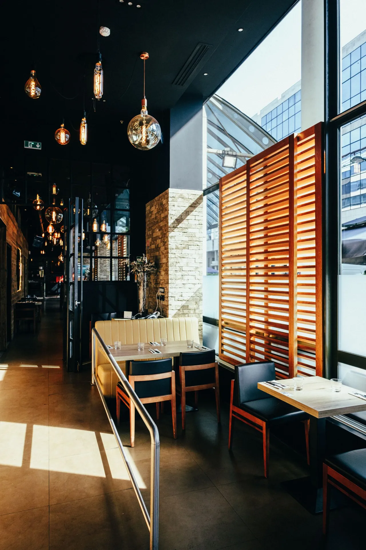 Restaurant dining tables with timber chairs, upholstered seating, and wooden screens